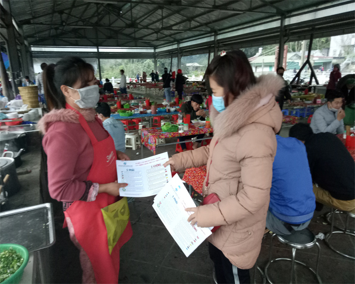 Cán bộ Hội LHPN thành phố Lai Châu phát tờ rơi tuyên truyền phòng chống dịch nCoV tới các hộ kinh doanh tại chợ San Thàng.